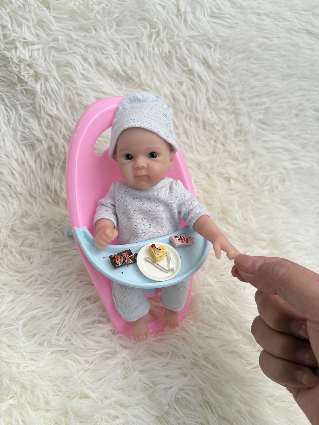 Sunshine Baby silicone doll in pink tub on fluffy background