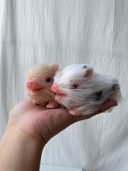 Miniature silicone pig doll held in hand - cream variant